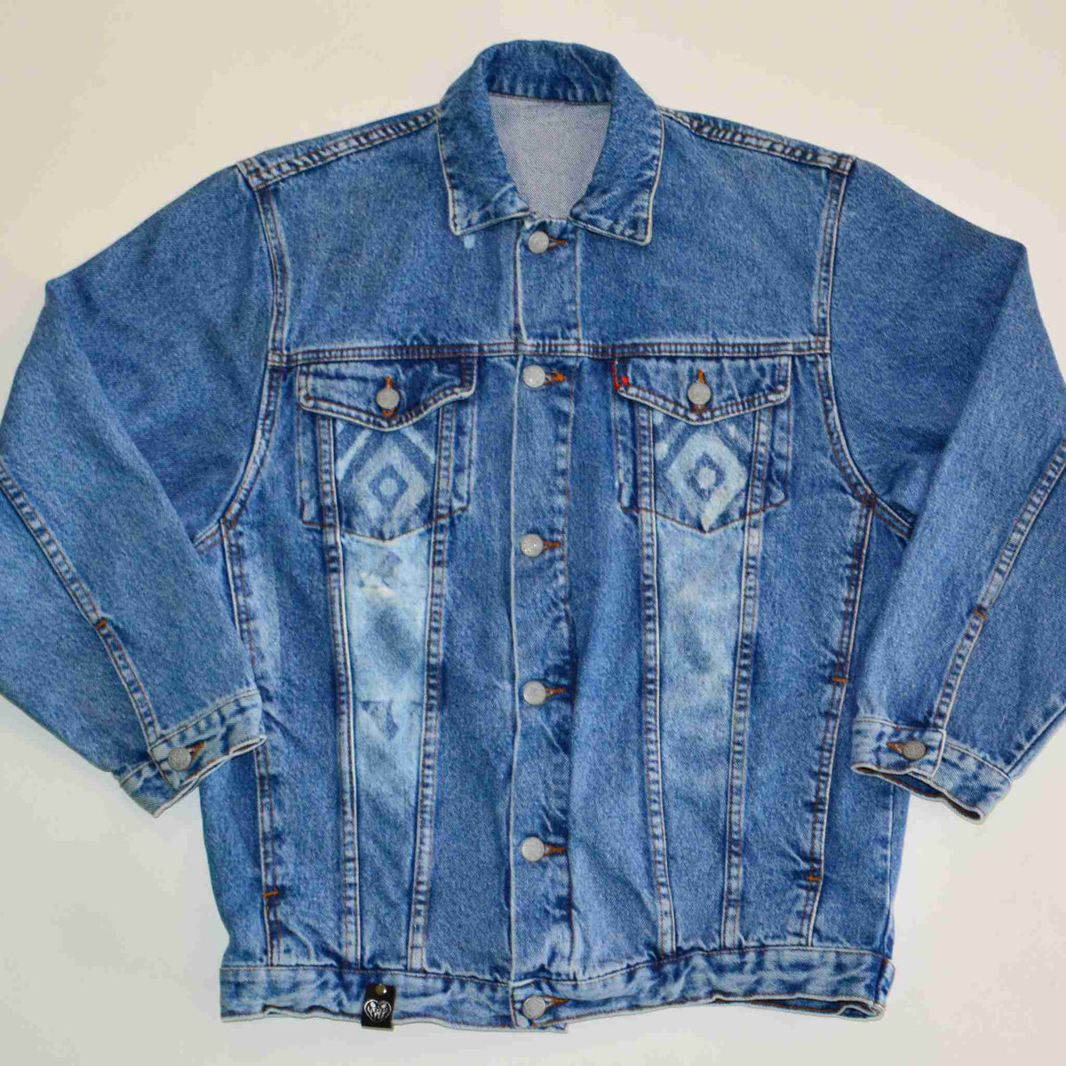 a blue jean jacket sitting on top of a white table.