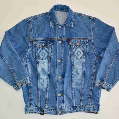 a blue jean jacket sitting on top of a white table.
