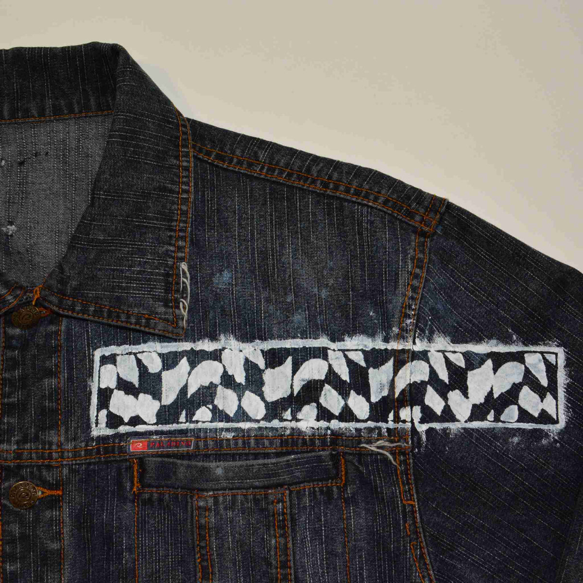 a denim jacket with a patch on the back of it.