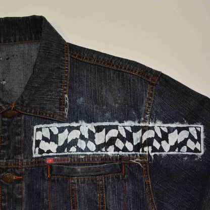 a denim jacket with a patch on the back of it.