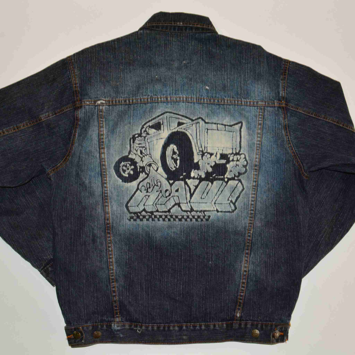 a jean jacket with a drawing of a car and a truck on it.