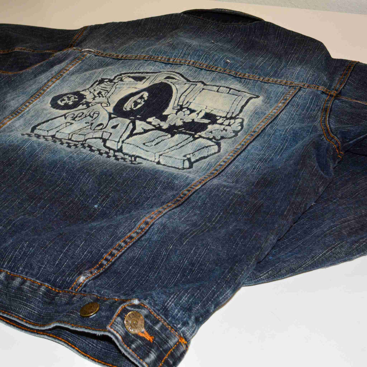 a jean jacket with a picture of a skull on it.