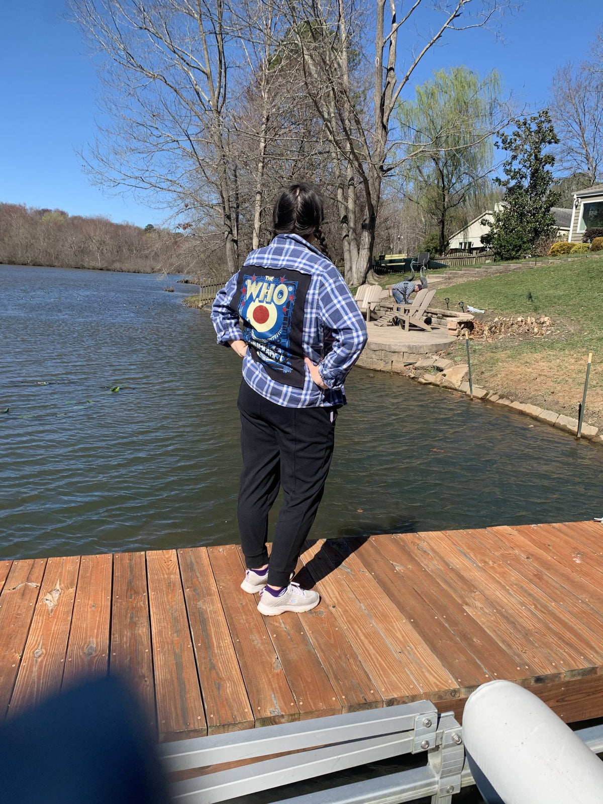 A person standing on a dock near a body of water.