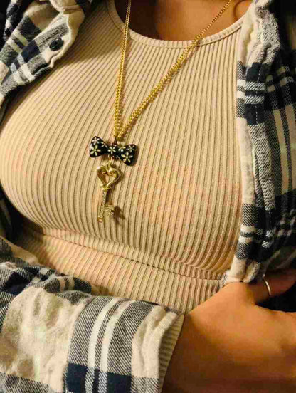 a woman wearing a plaid shirt and a bow tie necklace.