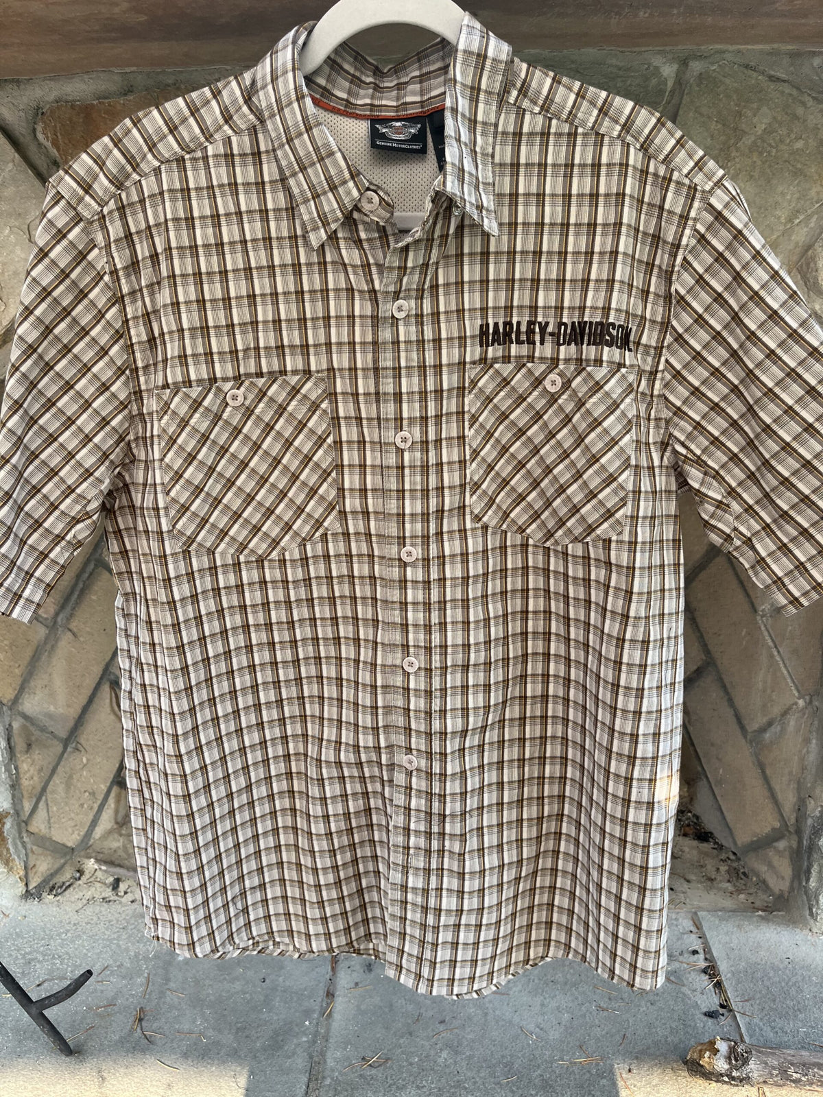 a brown and white checkered shirt hanging on a wall.