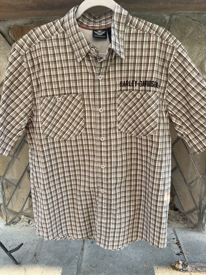a brown and white checkered shirt hanging on a wall.