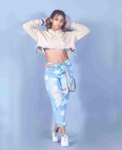 a woman wearing ripped jeans and a crop top.
