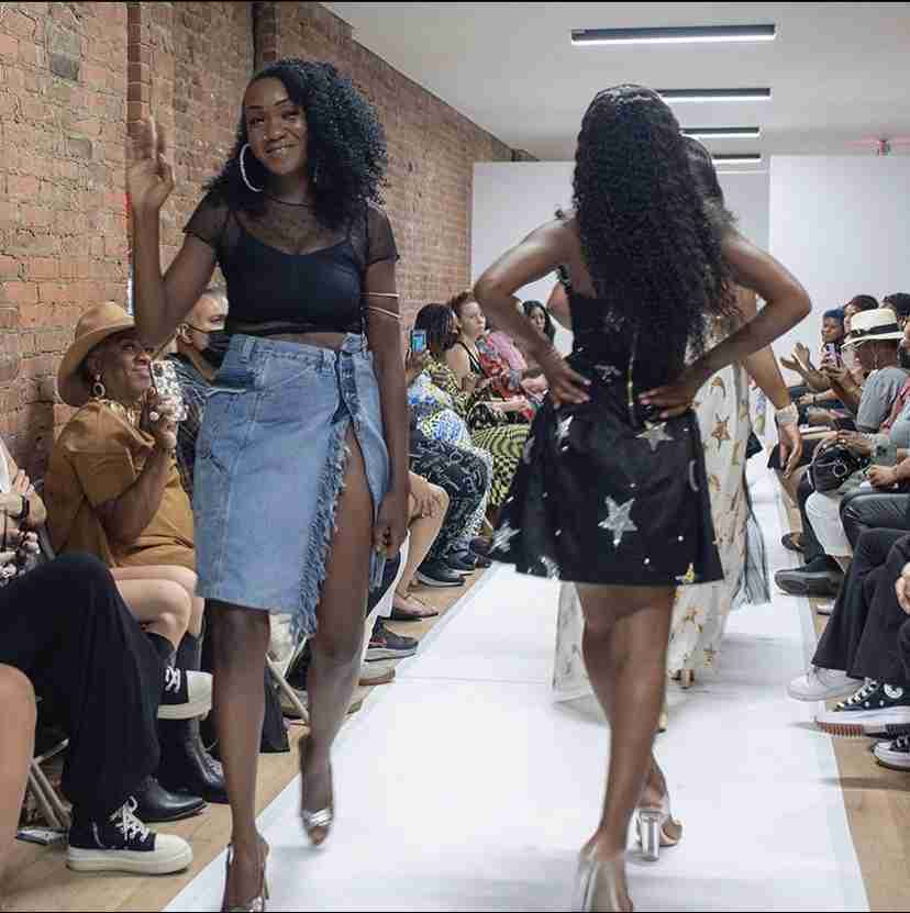 a couple of women walking down a runway.