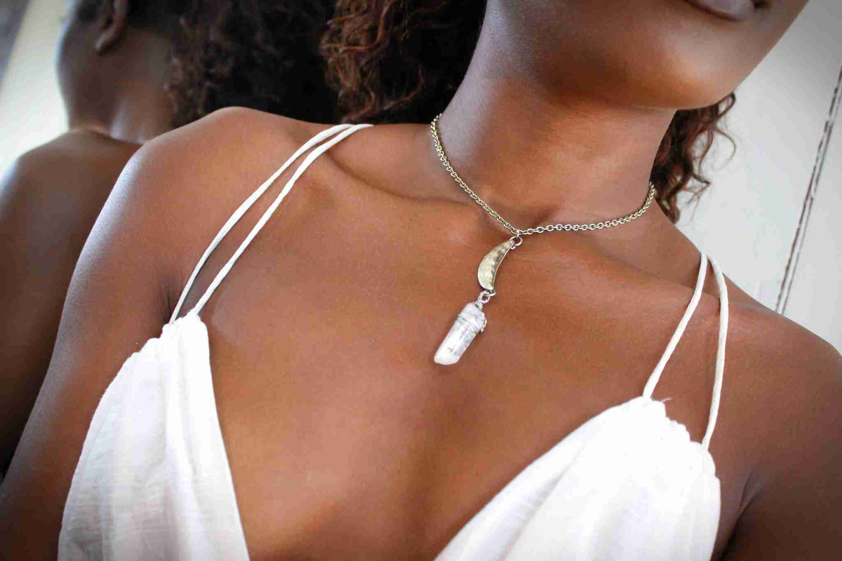 a woman wearing a white dress and a necklace.