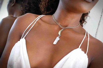a woman wearing a white dress and a necklace.
