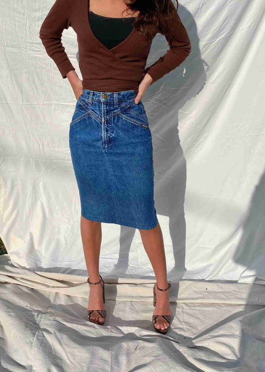 a woman standing in front of a white backdrop.