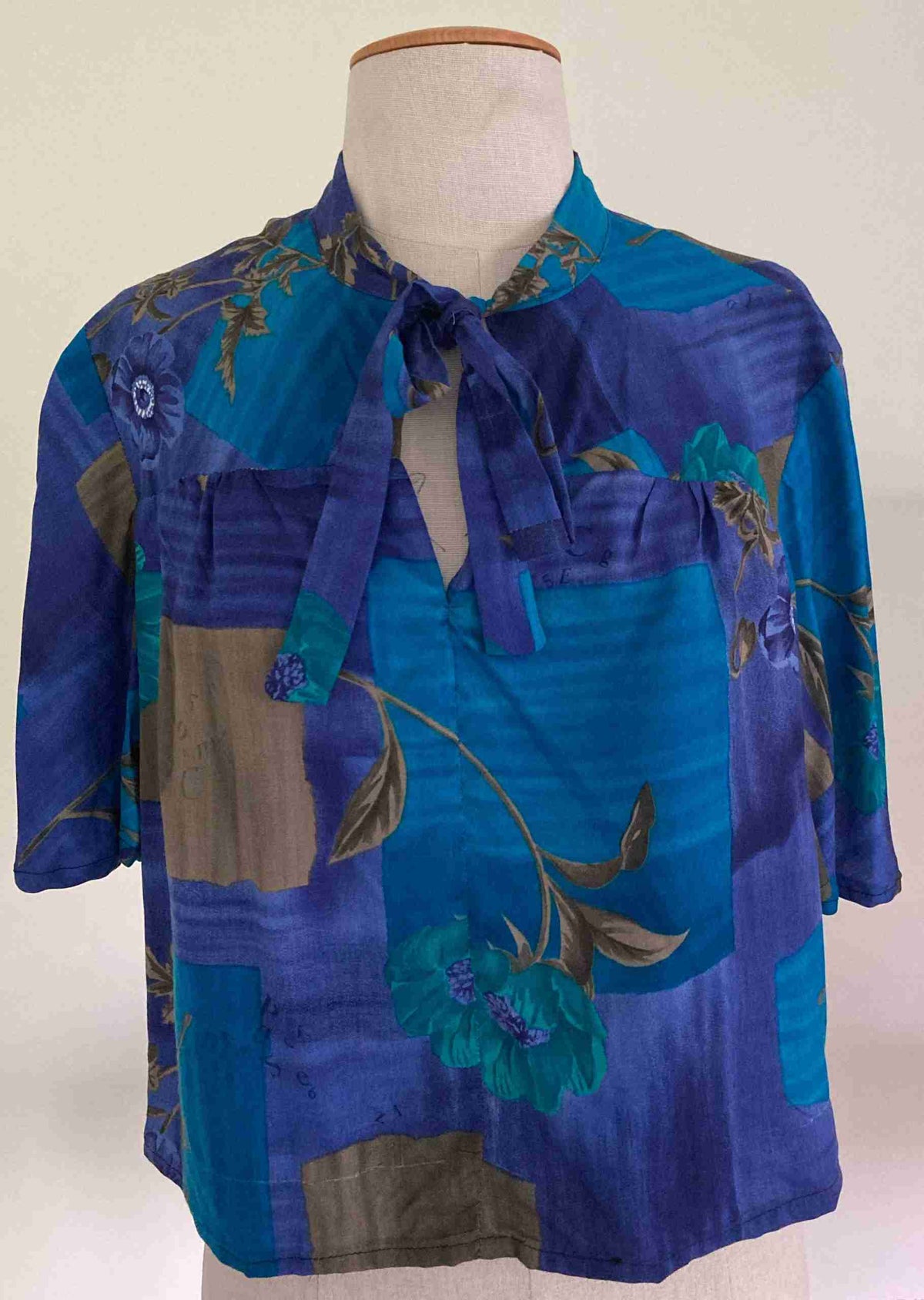 a mannequin wearing a blue shirt with flowers on it.