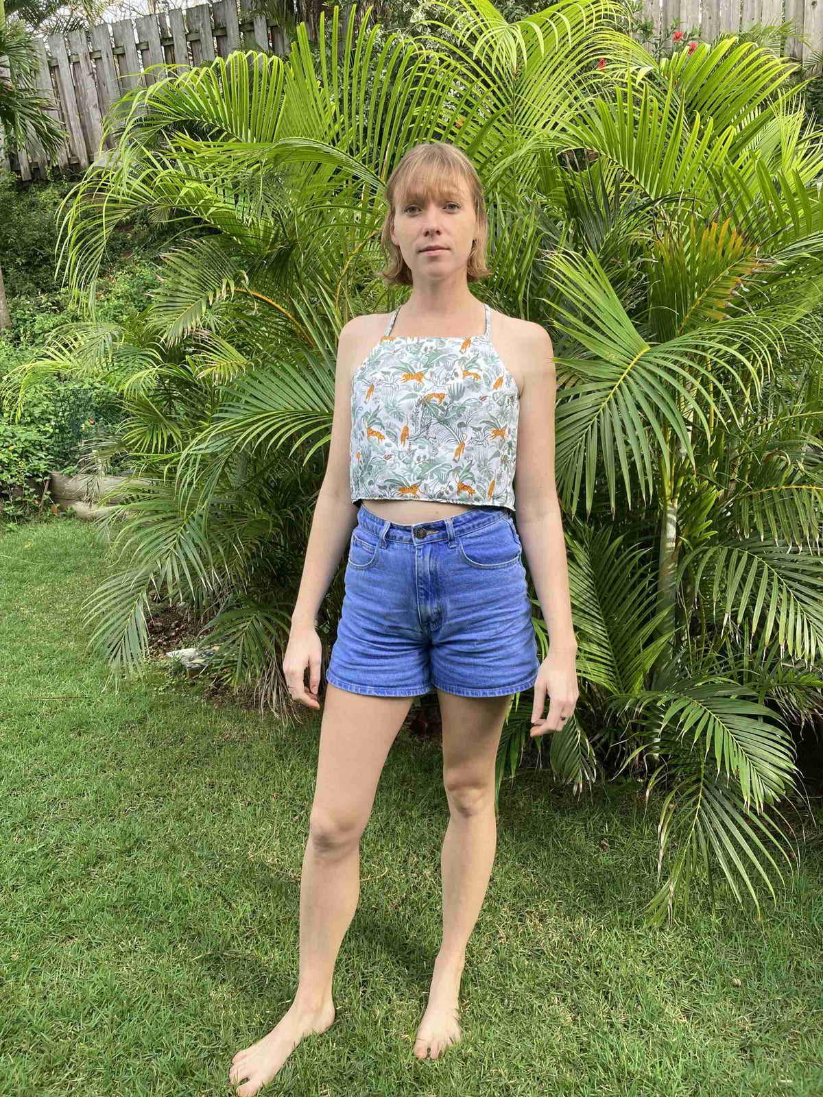 a woman standing in front of a bush.