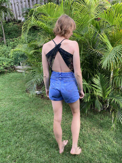 a woman standing in the grass with her back to the camera.
