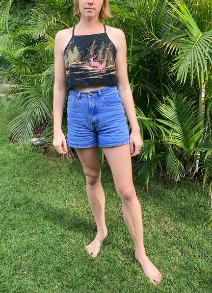 a woman standing in front of a bush.