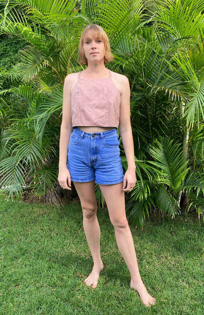 a woman standing in front of a bush.