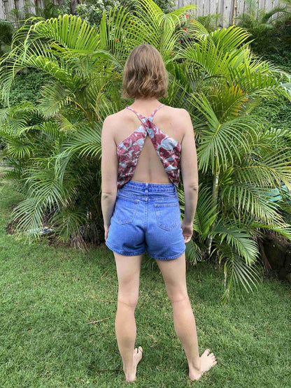 a woman standing in the grass with her back to the camera.