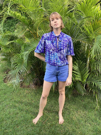 a woman standing in front of a bush.