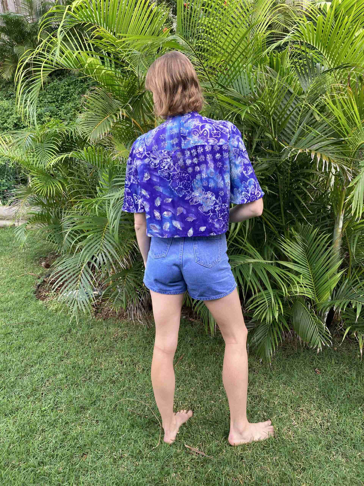 a person standing in front of a bush.