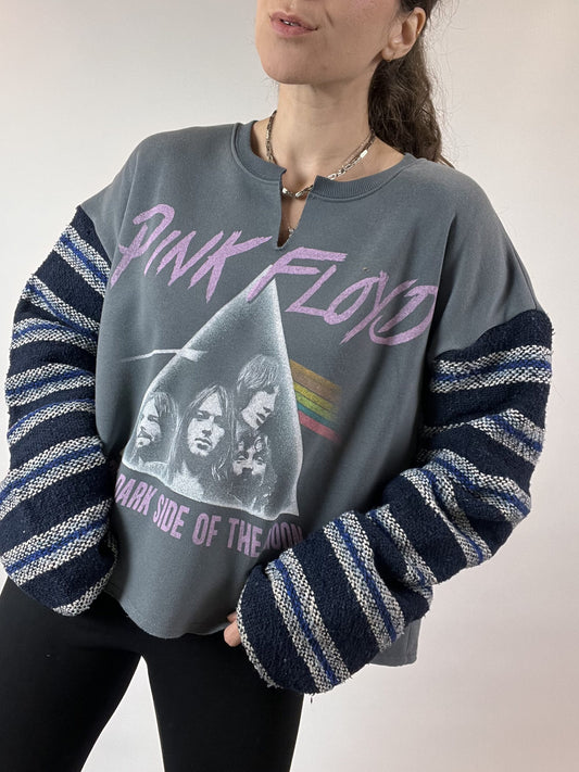 a woman wearing a pink floyd sweatshirt and black leggings.