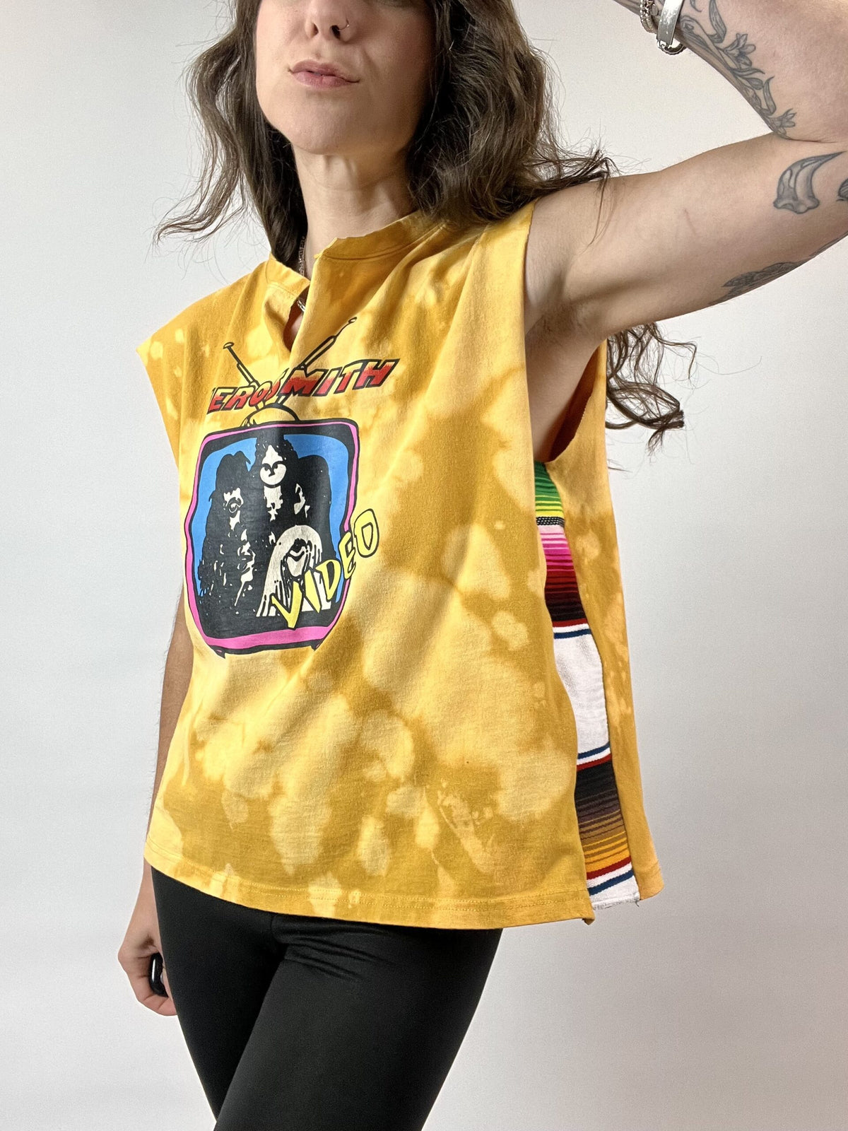 a woman wearing a yellow shirt and black pants.
