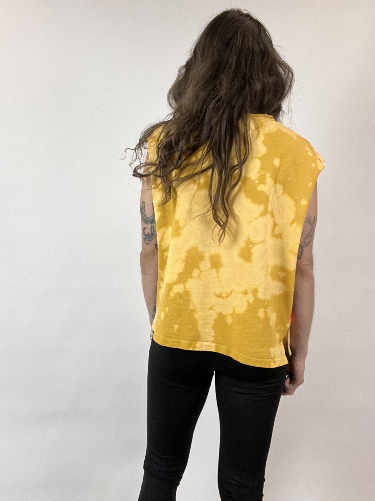 a woman with long hair wearing a yellow shirt.