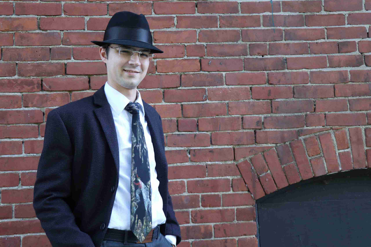 a man in a suit and tie standing in front of a brick wall.