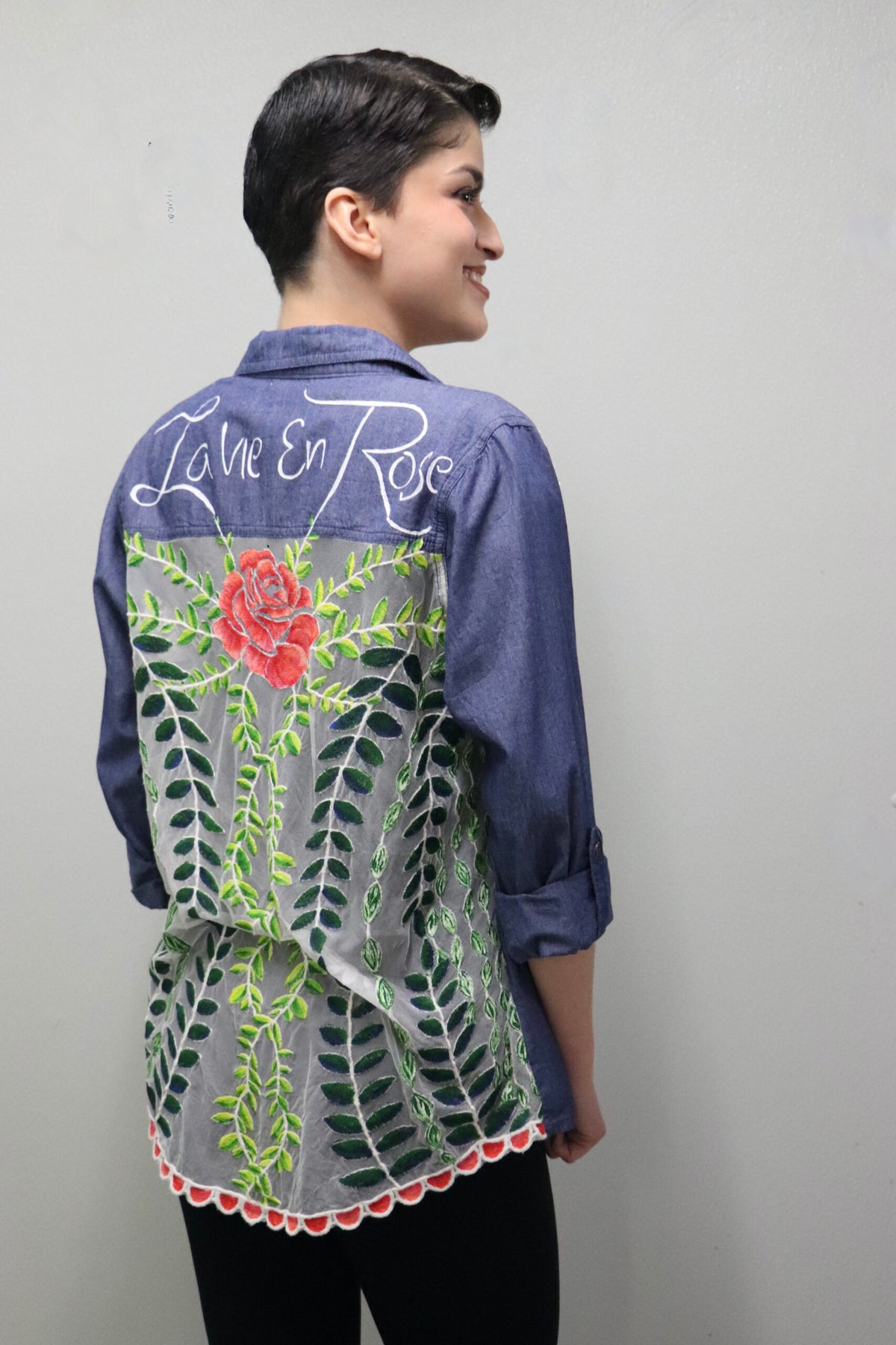 The back of a woman wearing a hand-painted shirt.