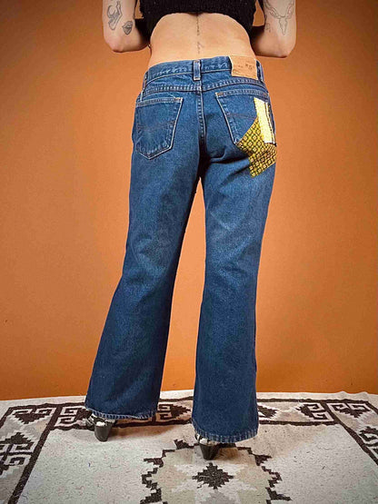 a woman with tattoos wearing a pair of jeans.