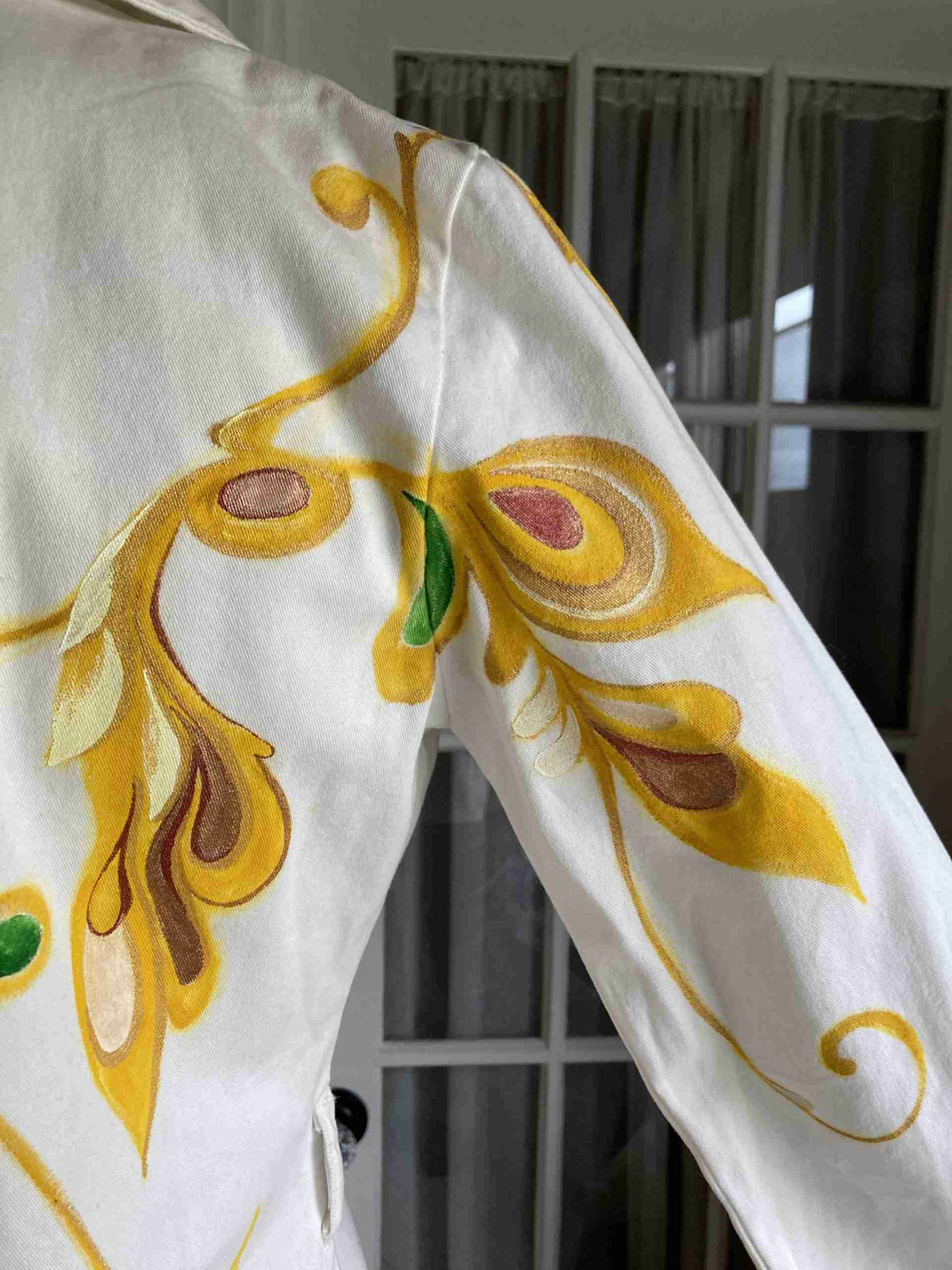 a close up of a white shirt with yellow and green designs.