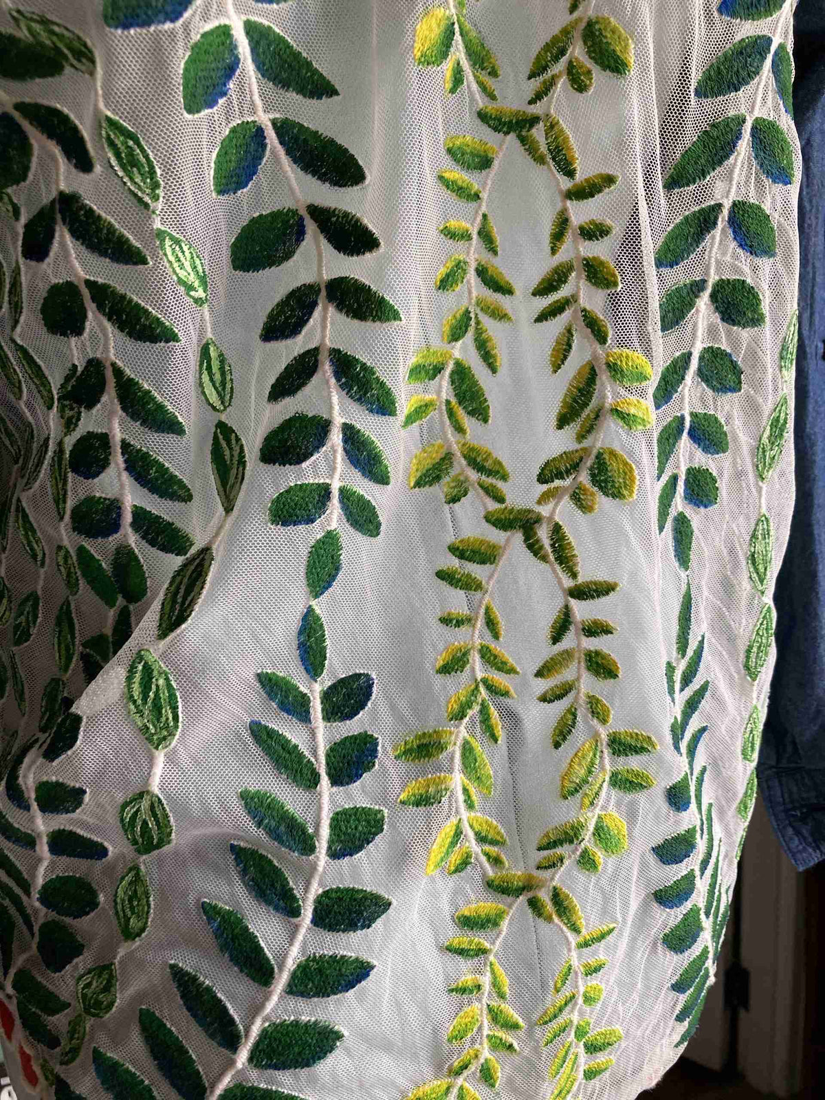 a white shirt with green leaves on it.