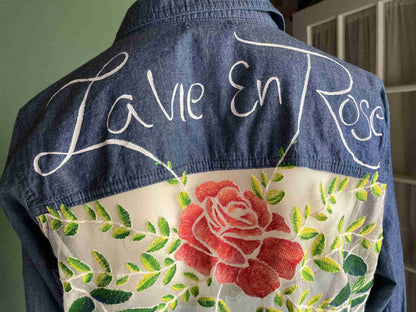 a denim jacket with a rose embroidered on it.