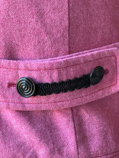 A close up of a pink jacket with black buttons.