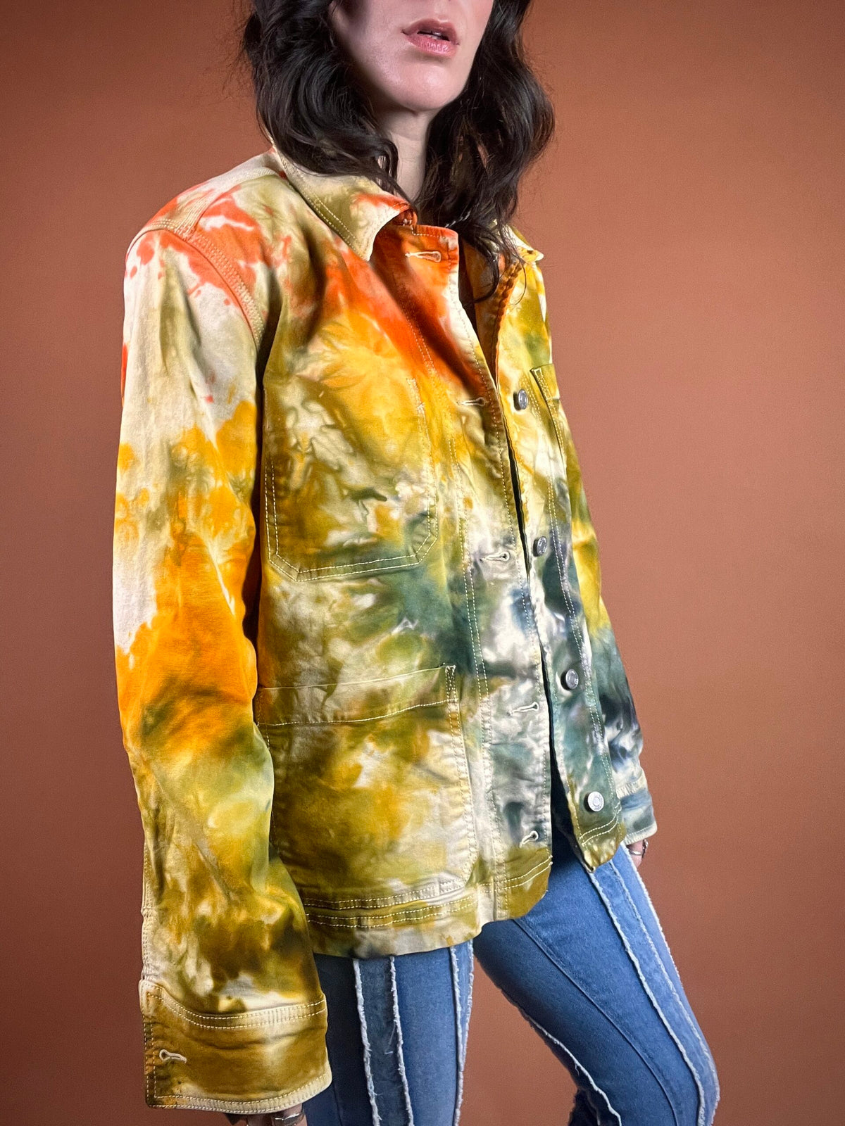 A woman wearing a tie dye denim jacket.