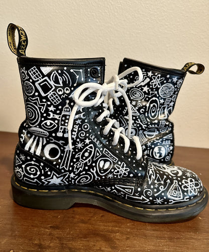 A pair of black and white dr martens boots.