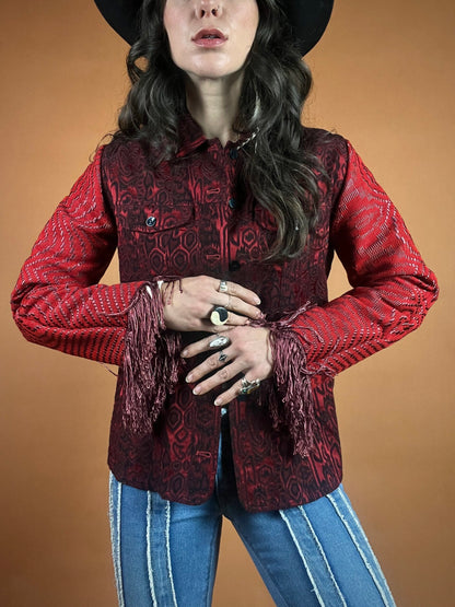A woman wearing a red jacket and a cowboy hat.