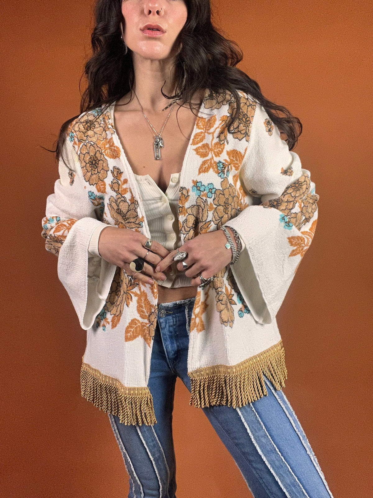 A woman wearing a fringed jacket and jeans.