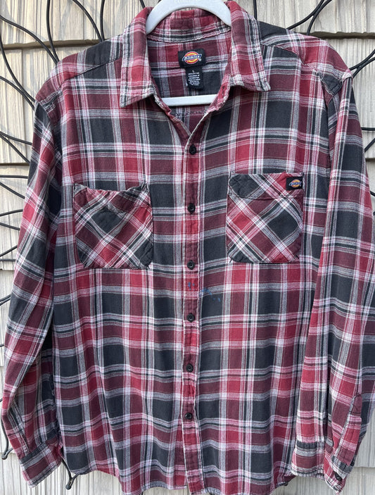 A red and gray plaid shirt hanging on a wall.