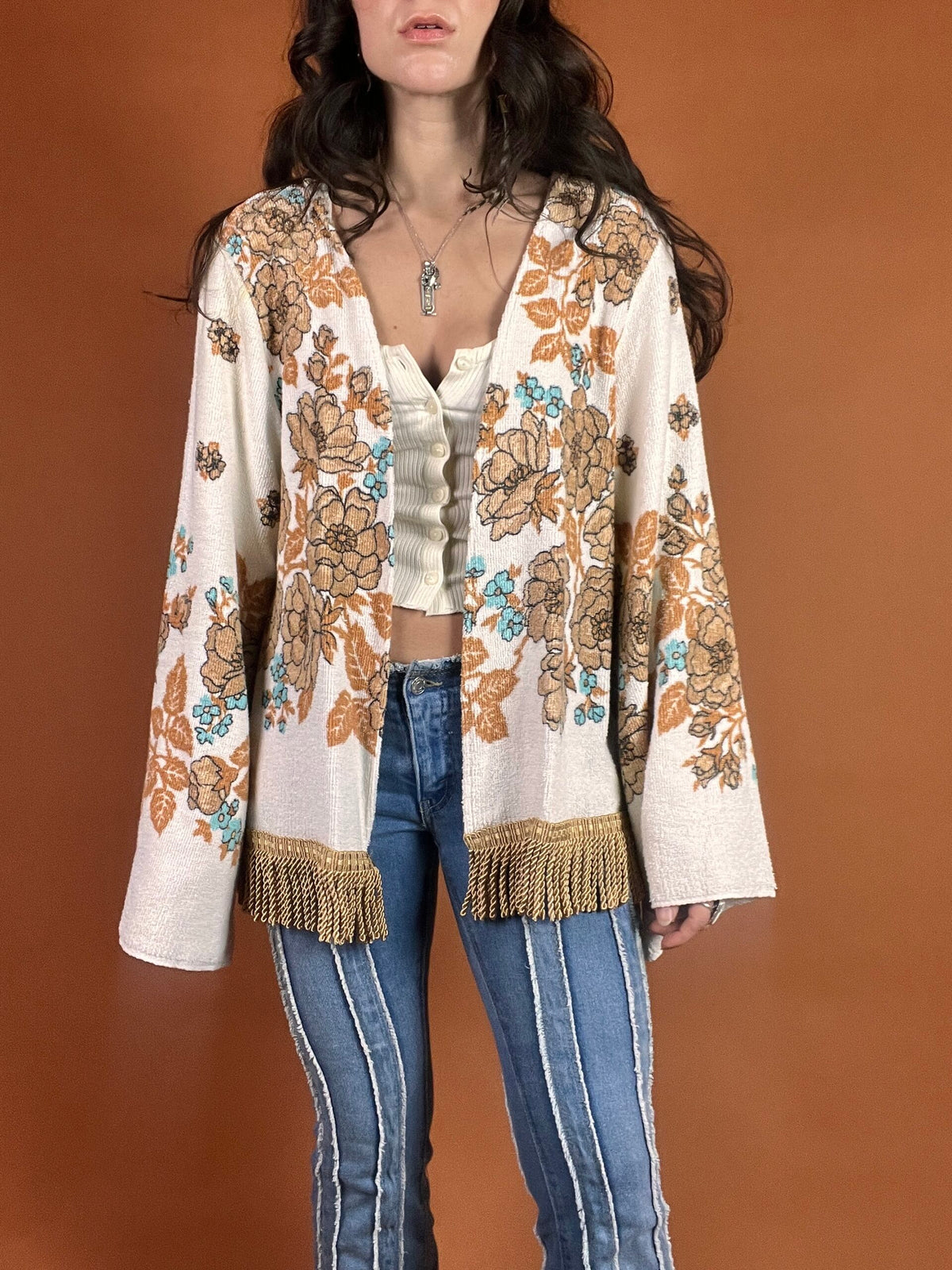 A woman wearing a fringed jacket and jeans.