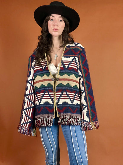 A woman in a hat and jeans poses for a photo.