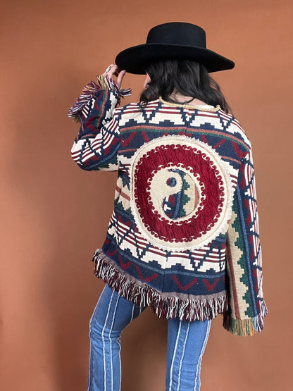 A woman wearing a fringed jacket and jeans.