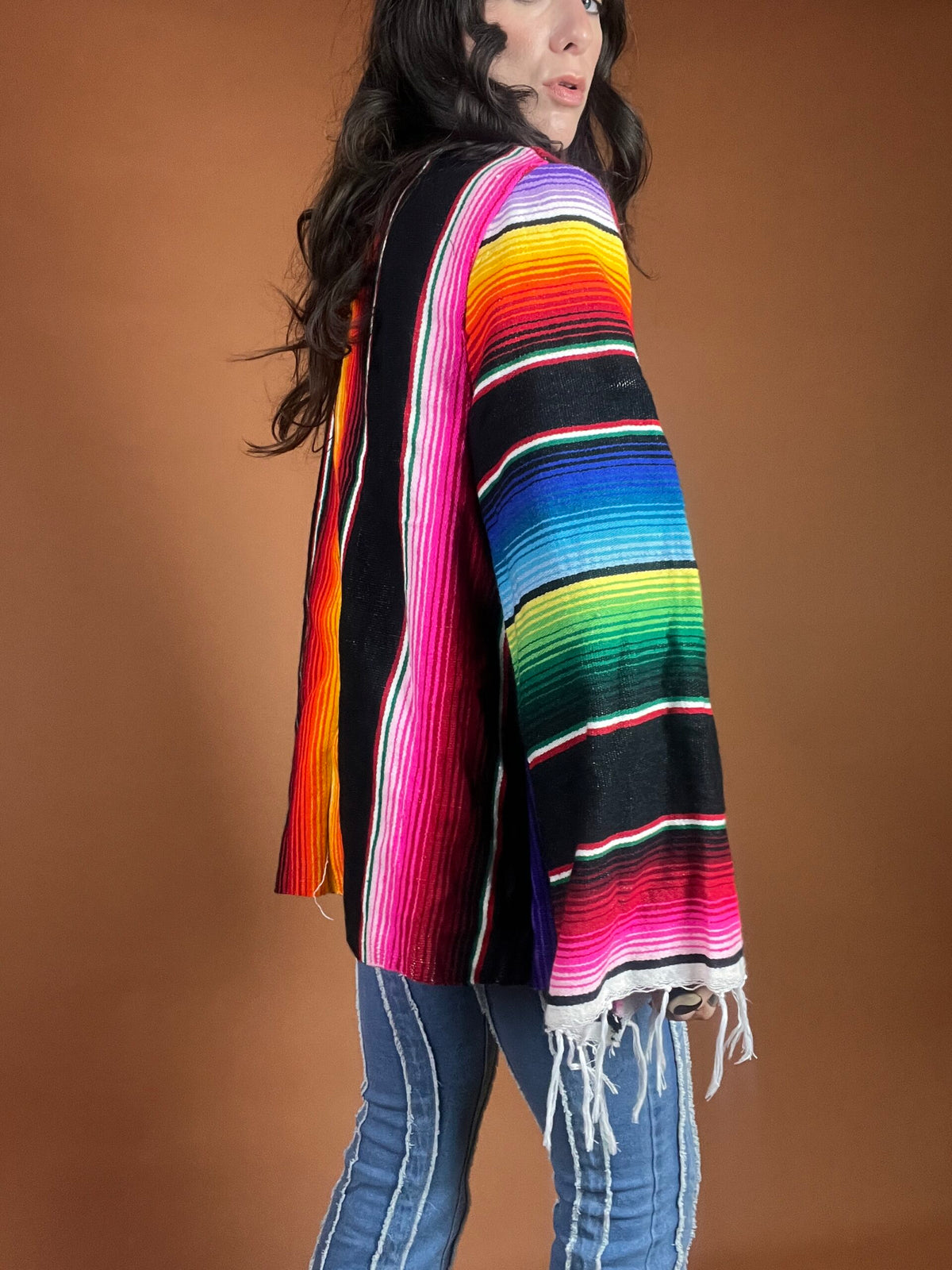 A woman wearing a colorful mexican poncho.