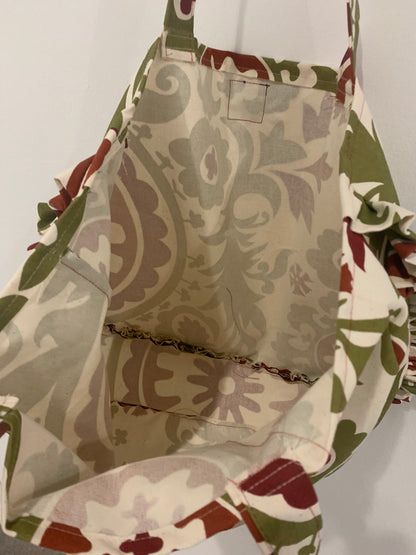 a green and brown tote bag hanging on a wall.