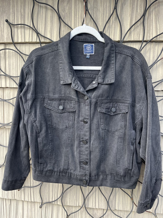 A black denim jacket hanging on a wall.