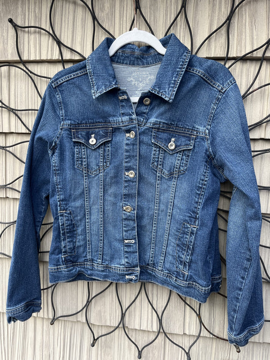 A denim jacket hanging on a wall.