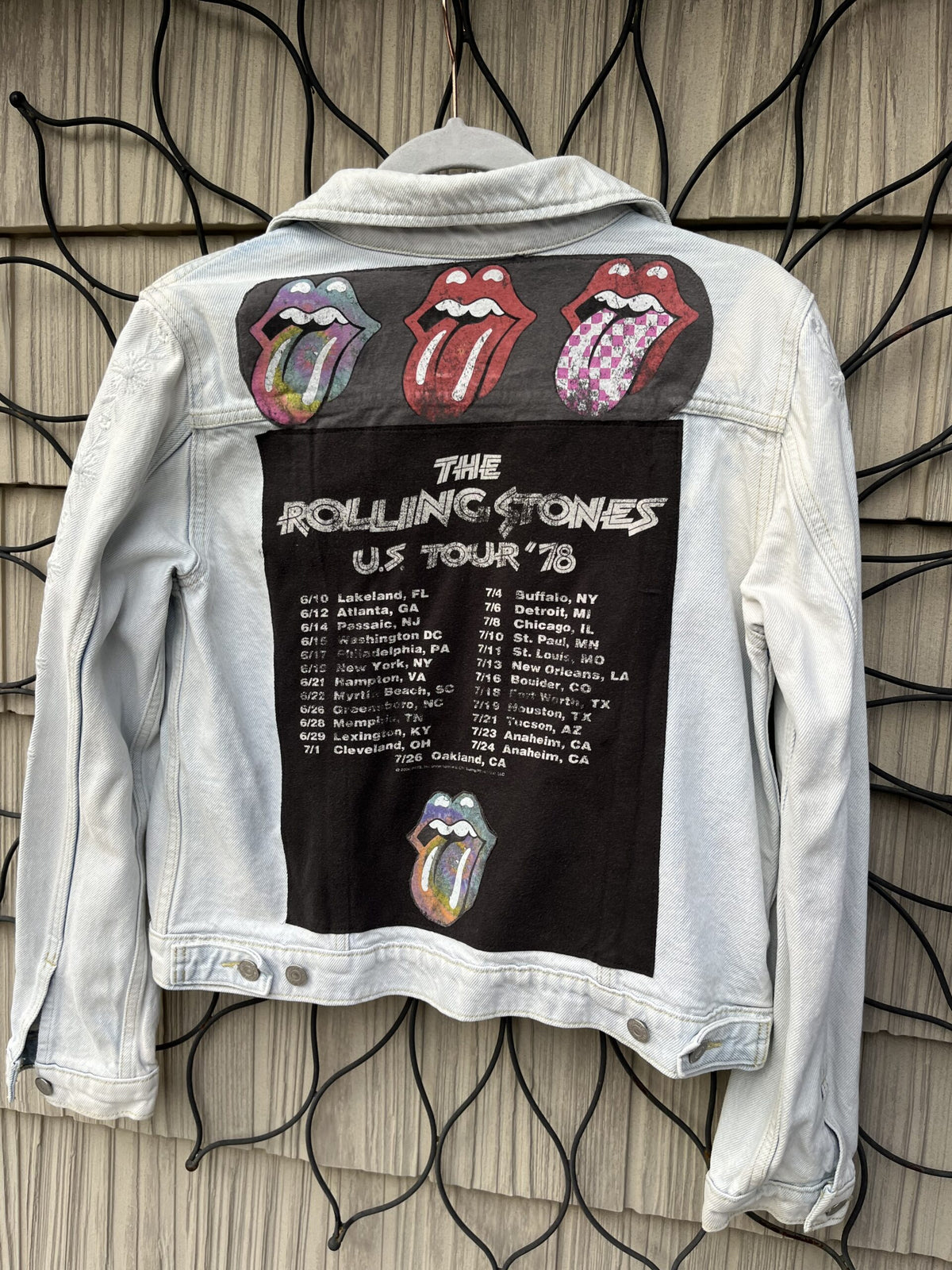 The rolling stones denim jacket hanging on a wall.