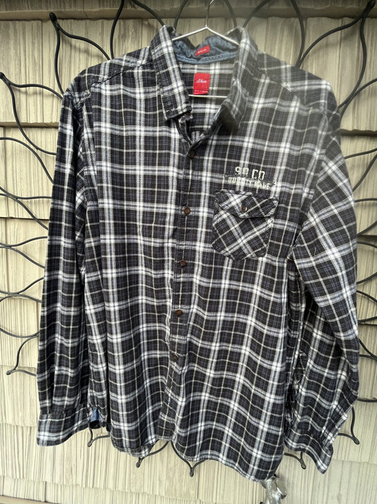 A black and white plaid shirt hanging on a wall.