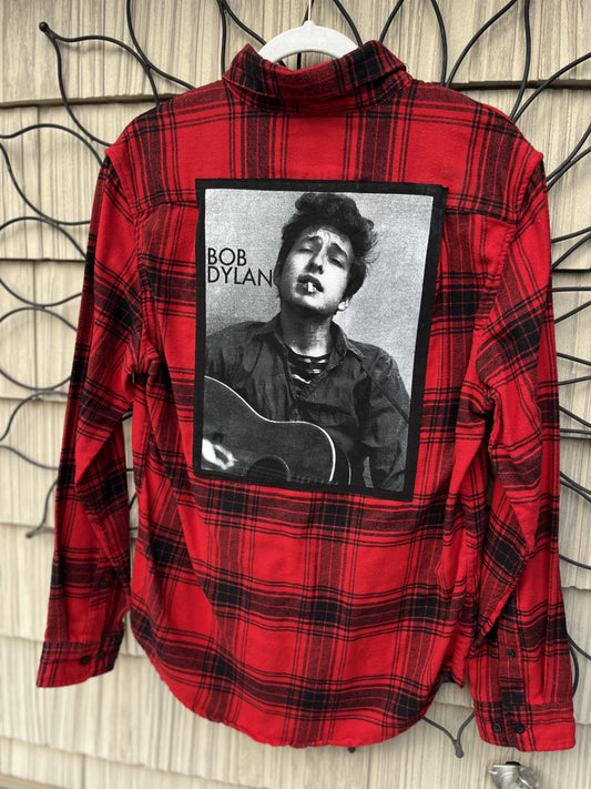A red and black flannel shirt with a picture of bob dylan.
