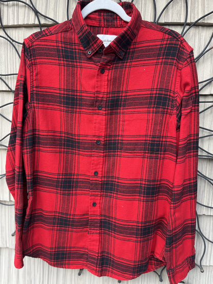A red and black plaid shirt hanging on a wall.