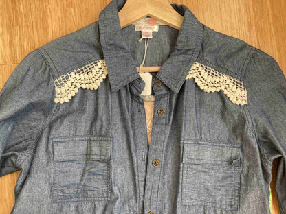 a denim shirt with white lace on the sleeves.